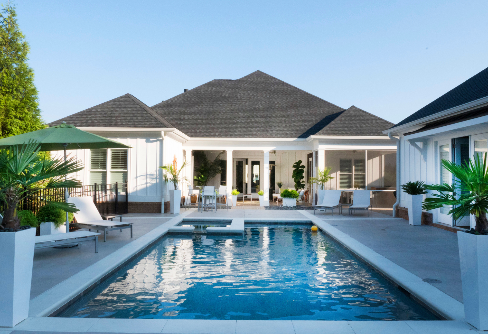 A large white house with a large swimming pool in front of it