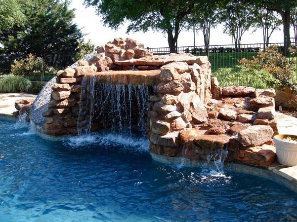 A large waterfall in the middle of a swimming pool