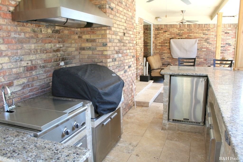 A kitchen with a grill and a brick wall