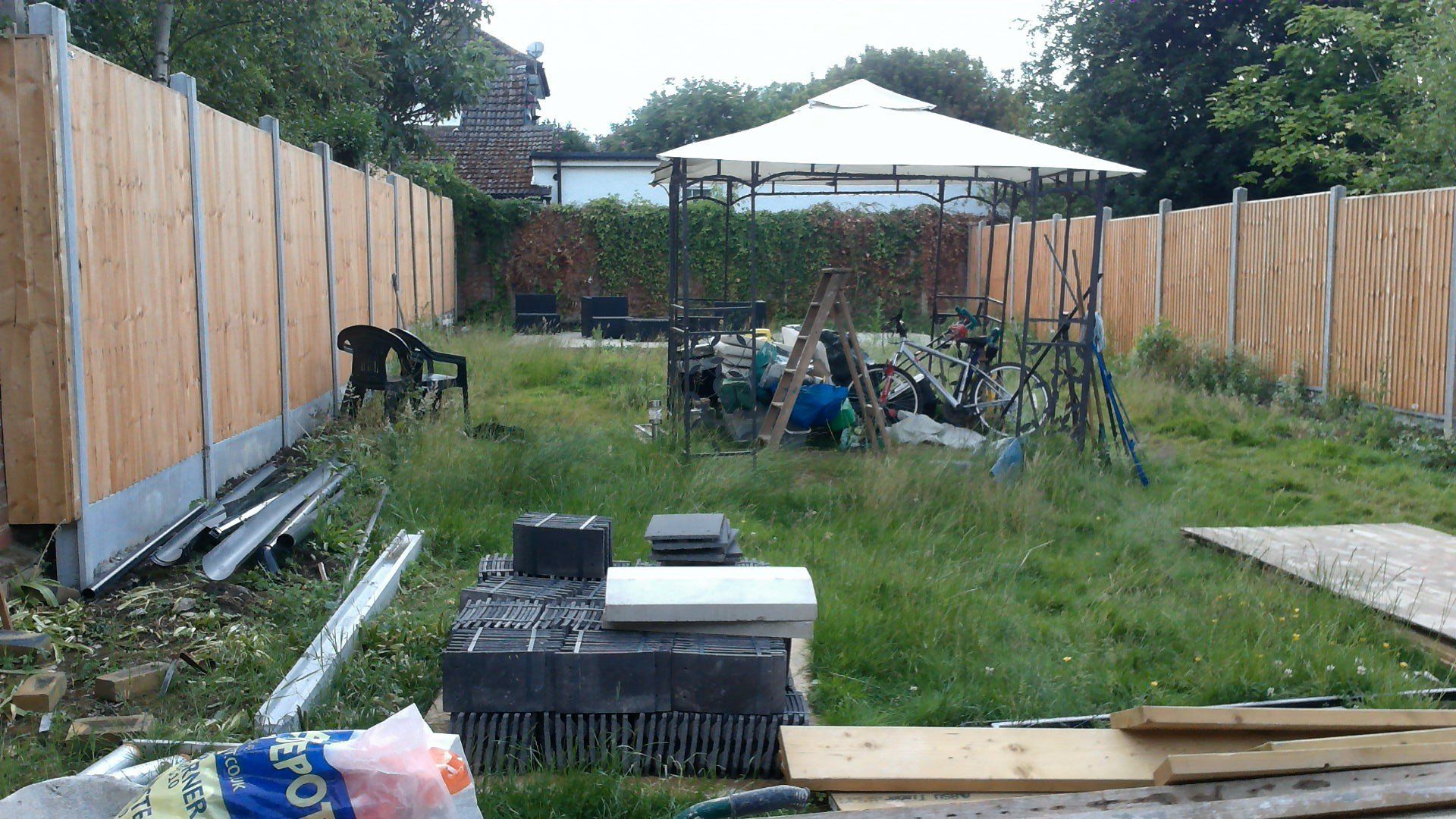 A backyard with a wooden fence and a gazebo