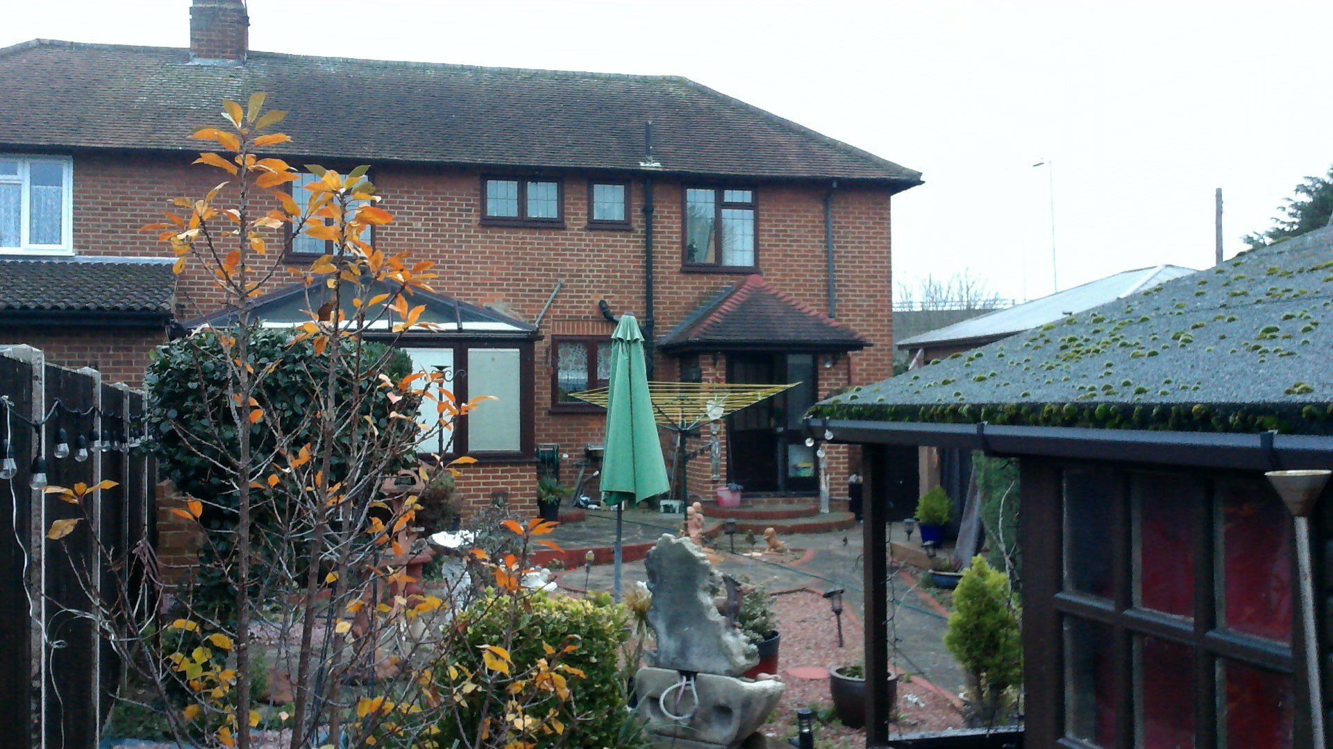 A brick house with a green umbrella in front of it