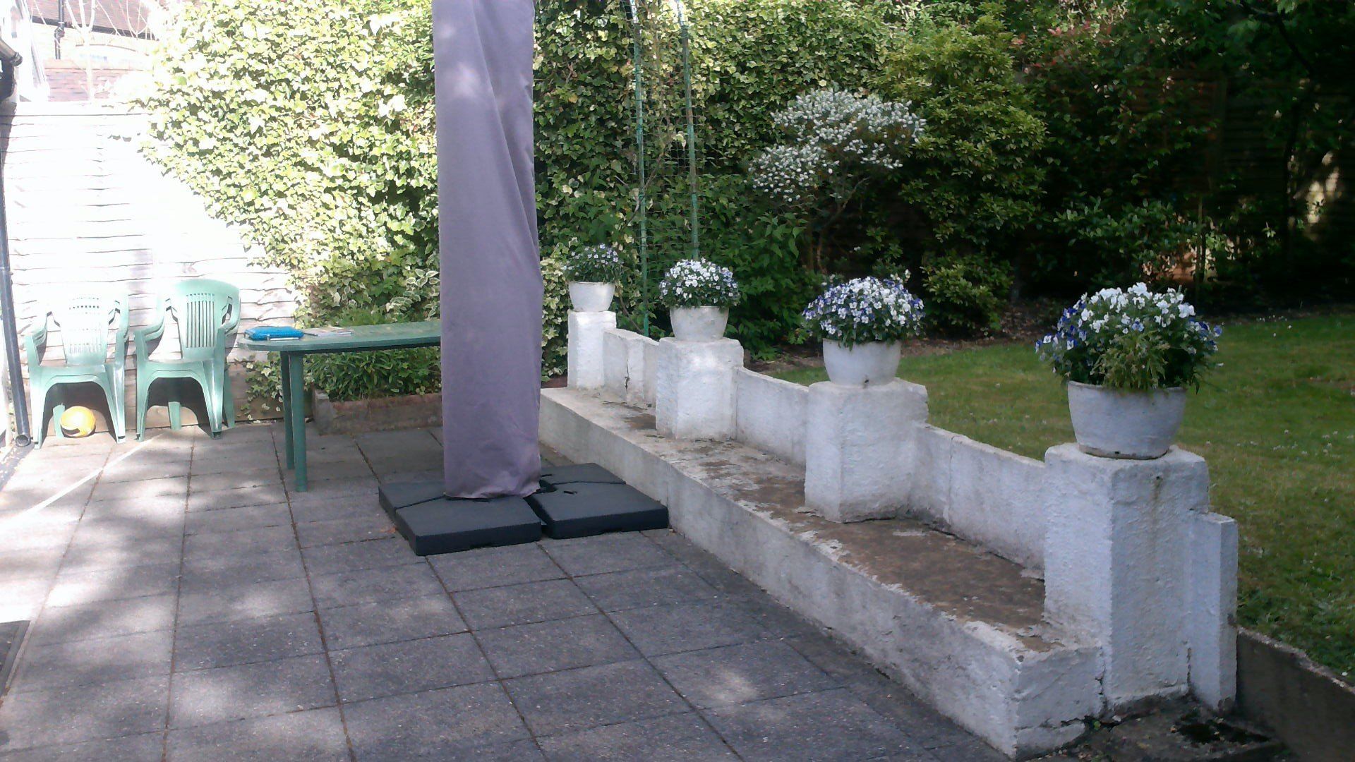 A patio with a table and chairs and potted flowers