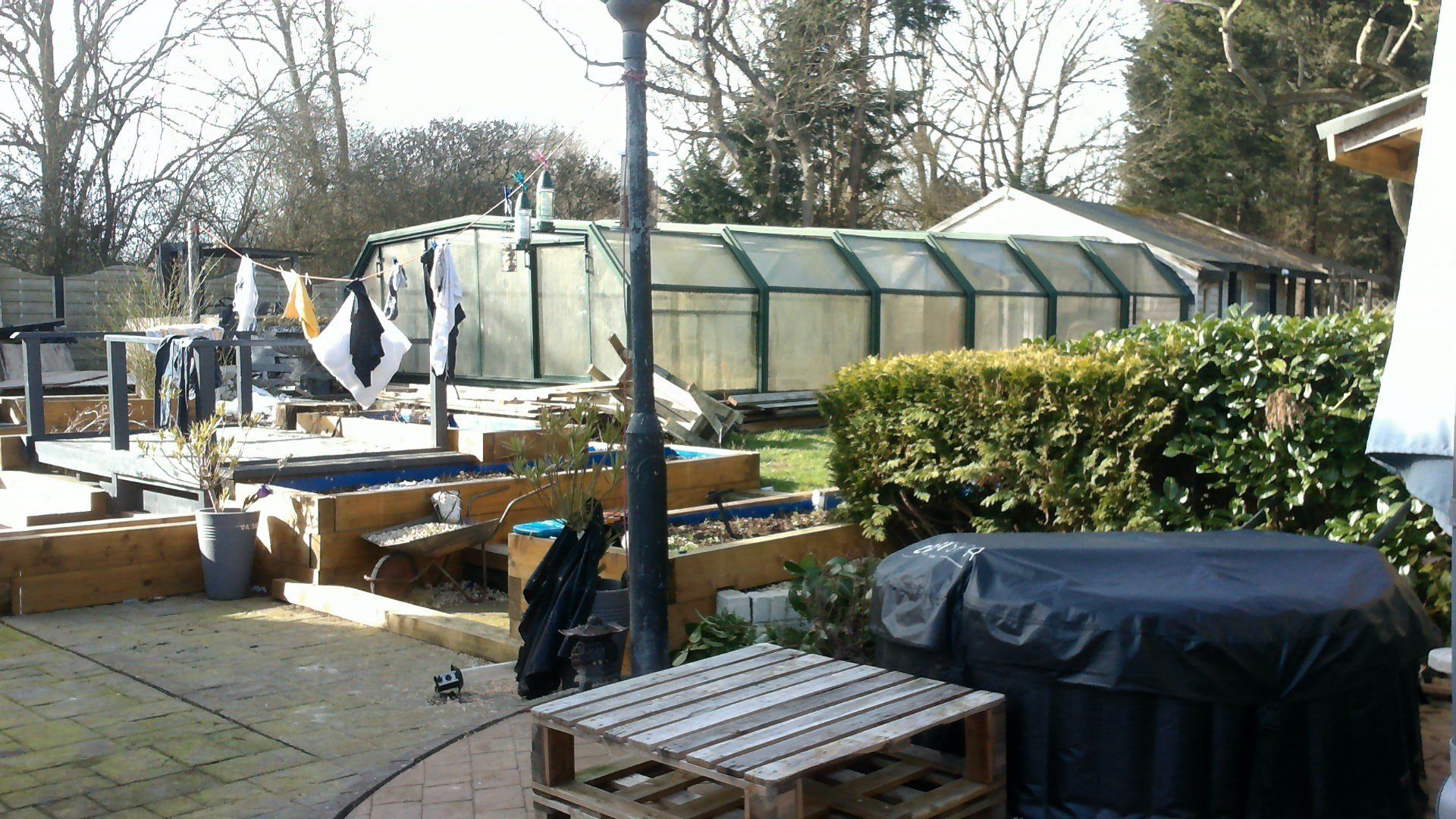 A patio area with a swimming pool in the background