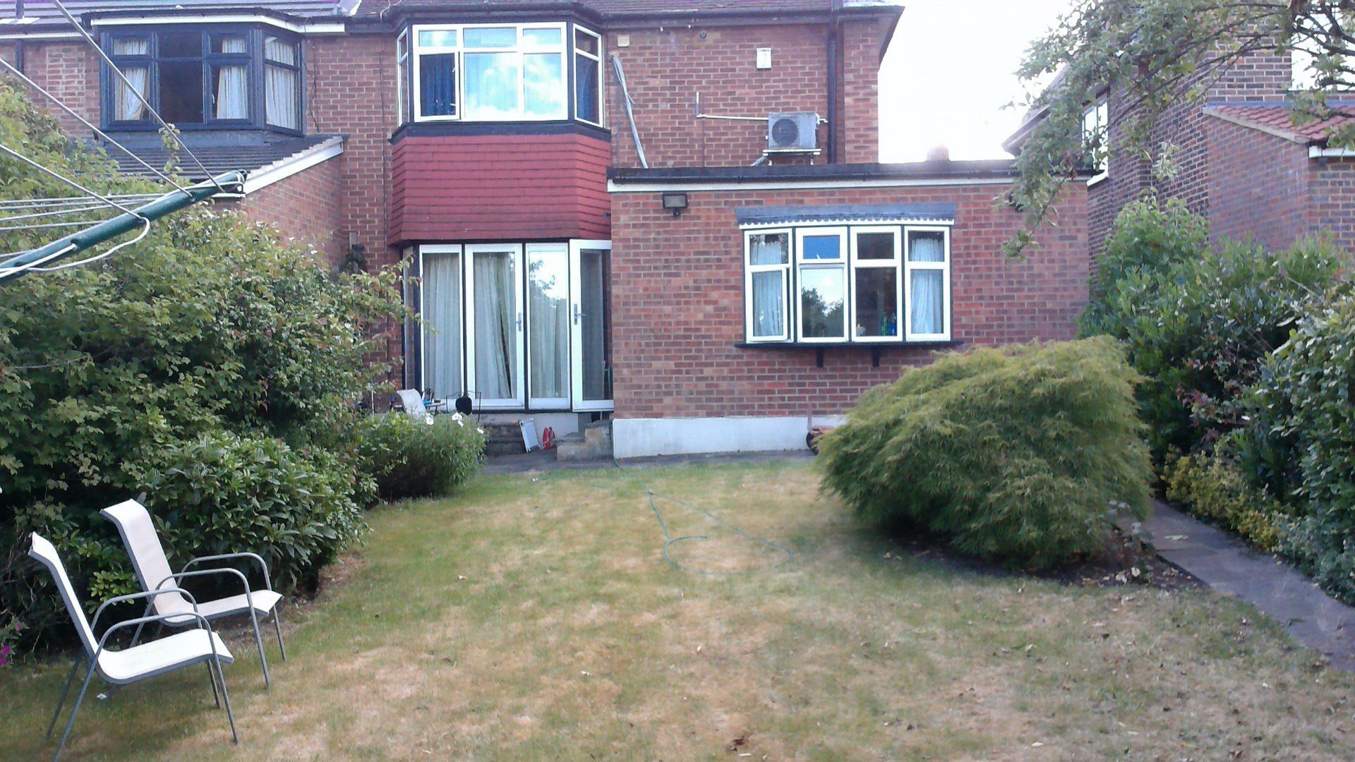 A large brick house with a large lawn in front of it