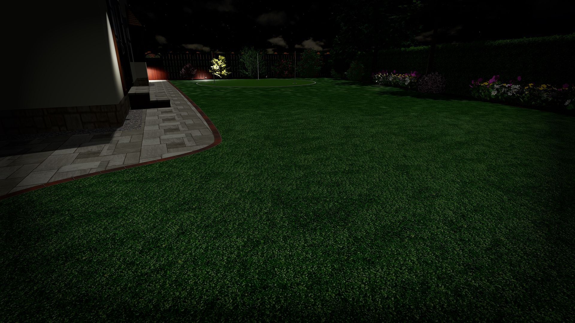 A lush green lawn is lit up at night in a backyard.