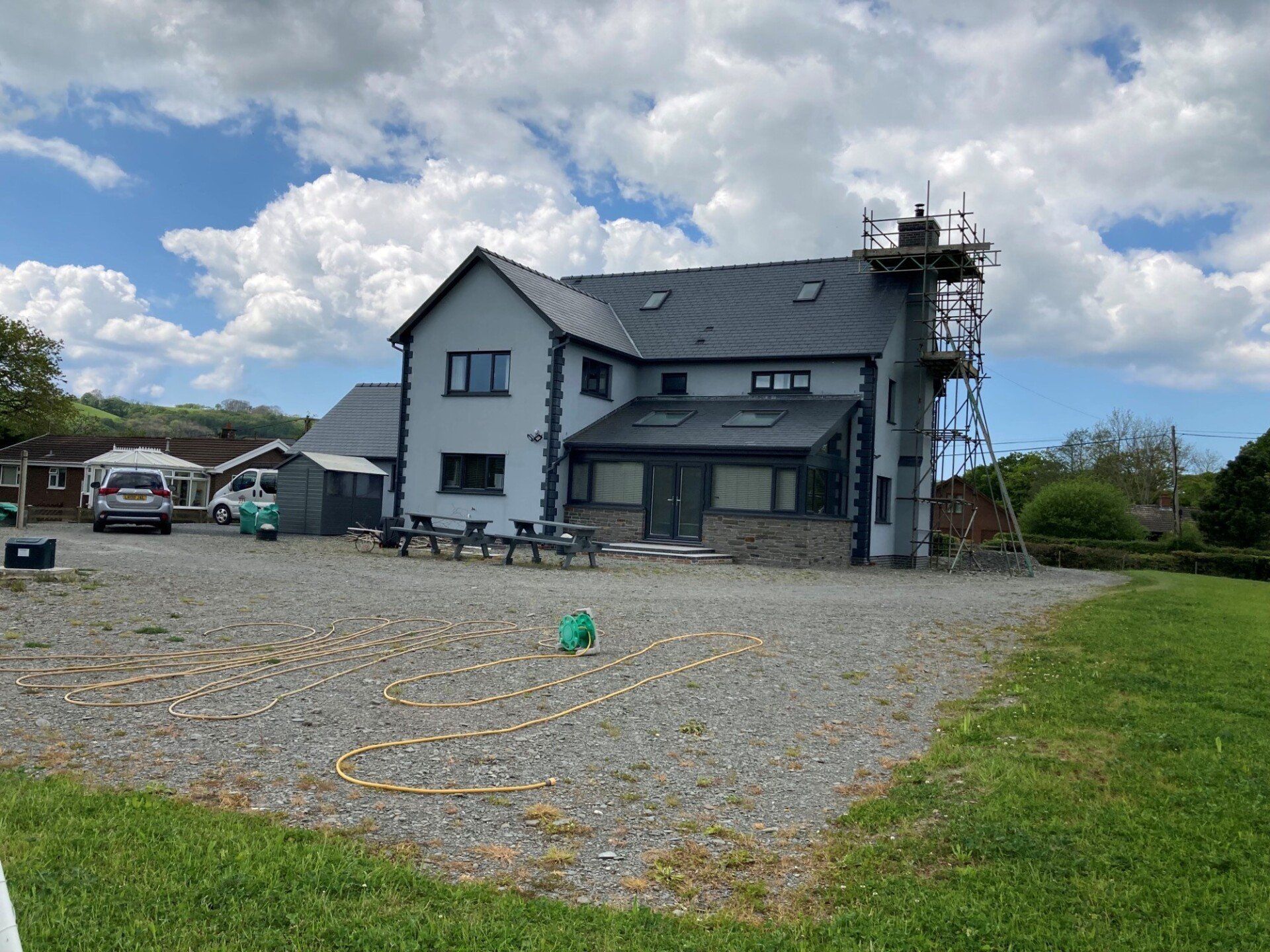 A large house with a scaffolding on the side of it is being built.