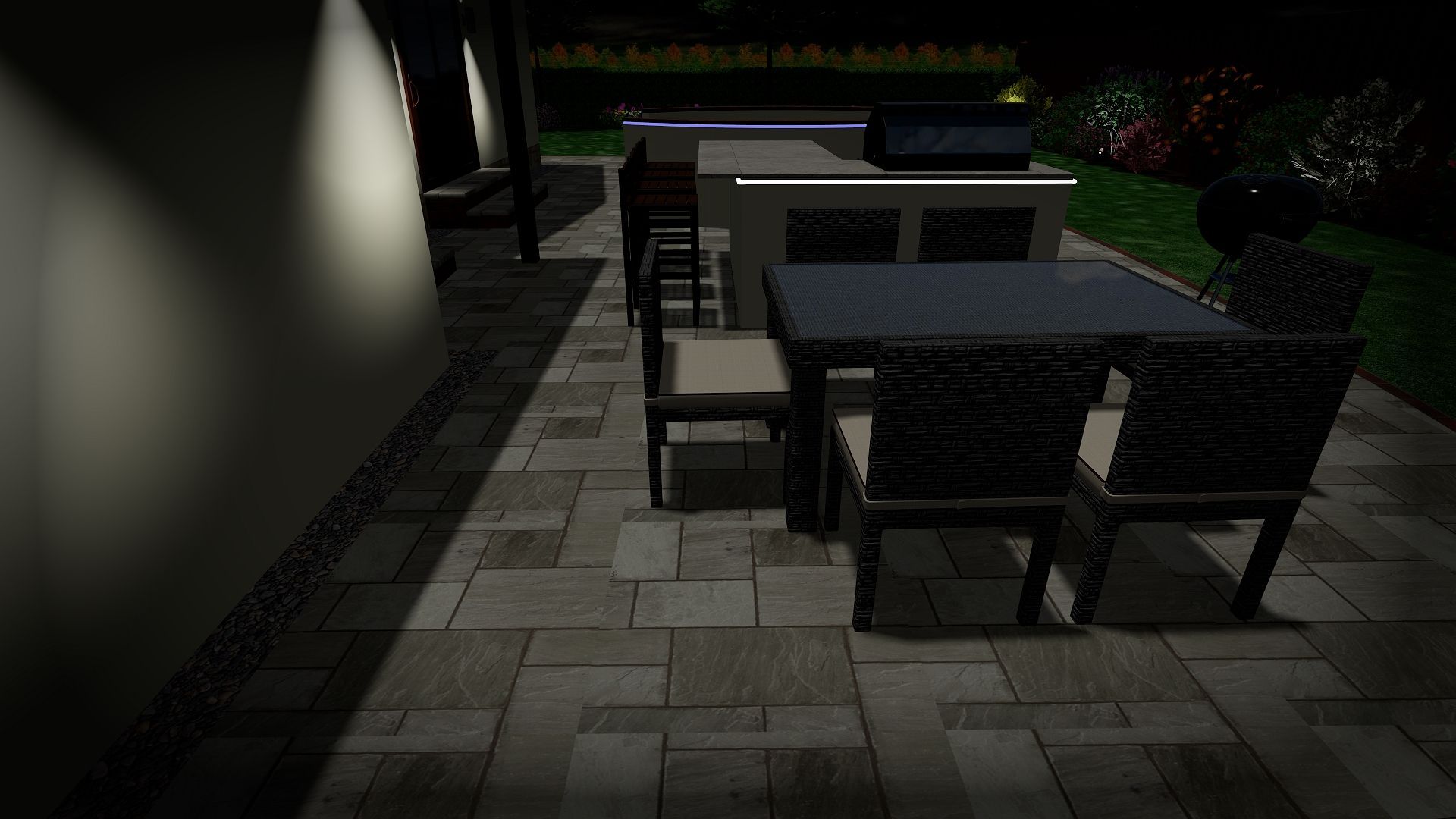 A patio with a table and chairs at night.