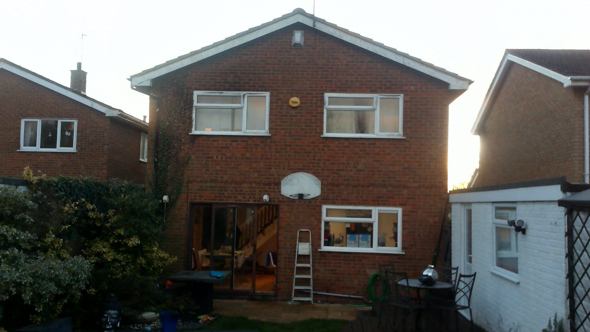 A brick house with white windows and a white roof