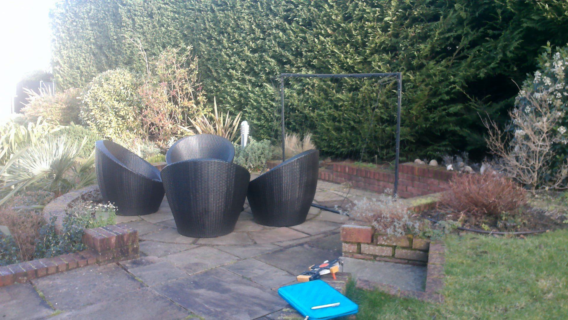 A group of chairs are sitting on a patio in a garden.