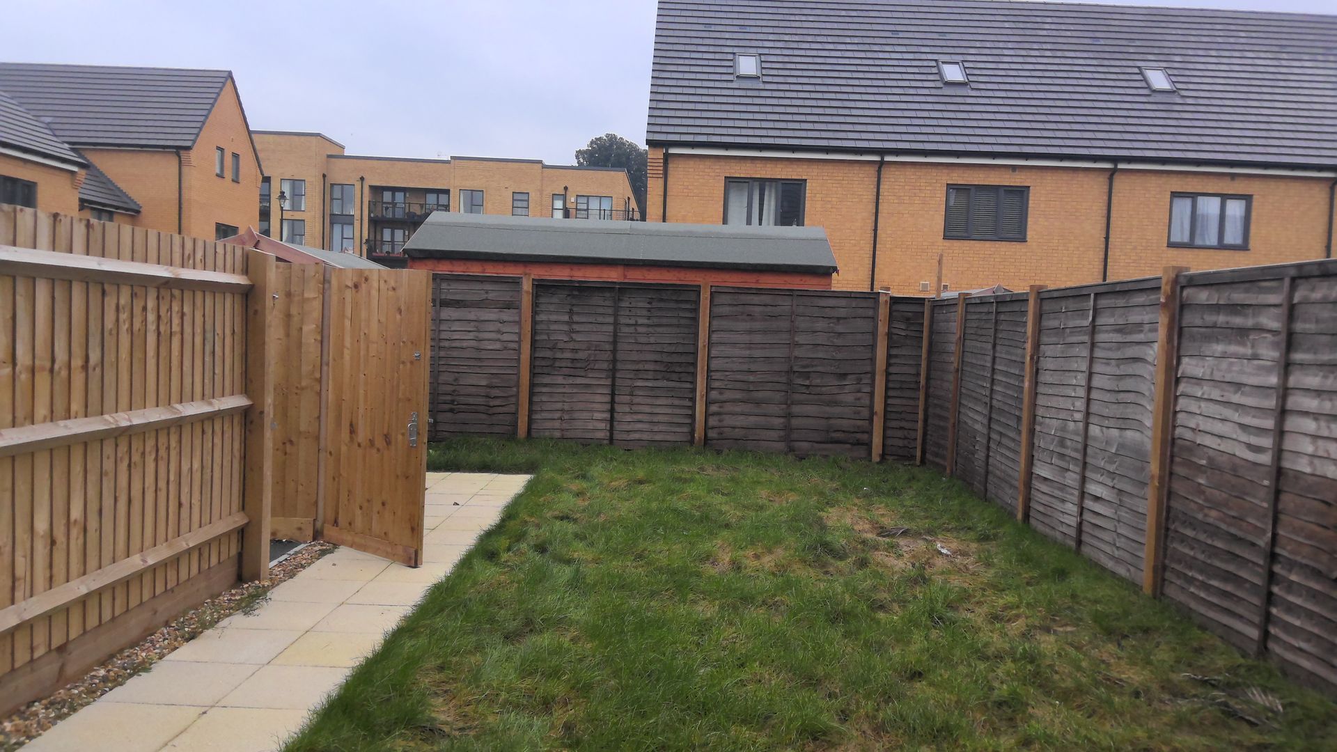 There is a wooden fence in the backyard of a house.