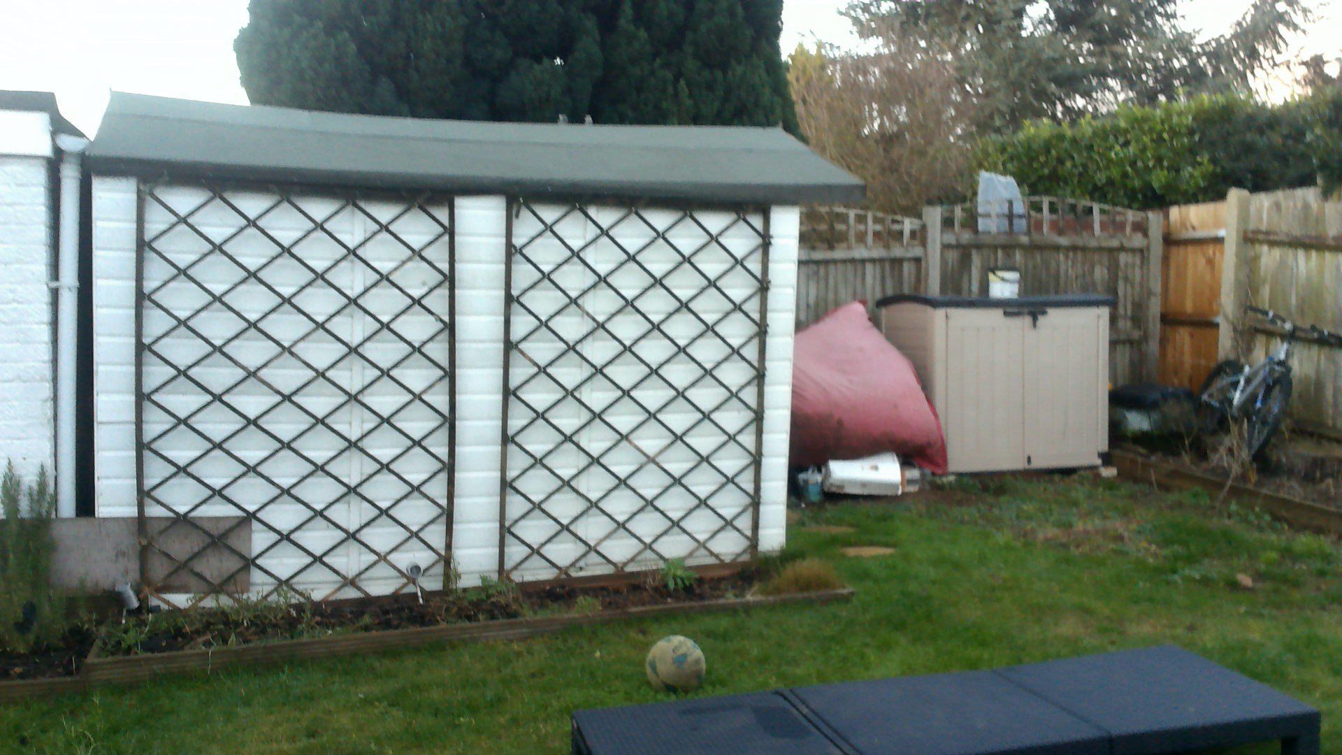 A backyard with a shed and a table in the foreground