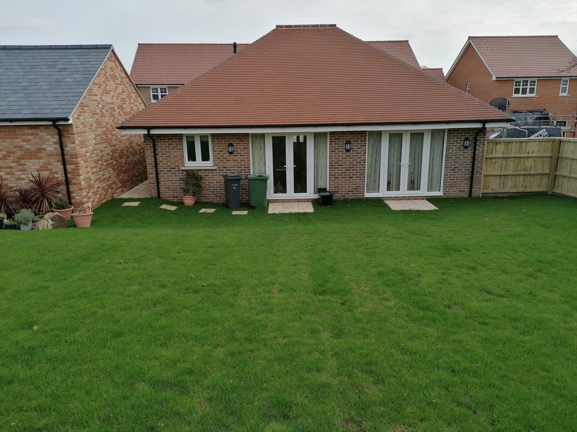 The back of a house with a large lawn in front of it.