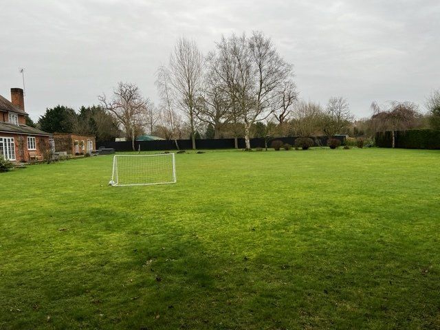 There is a soccer goal in the middle of a lush green field.