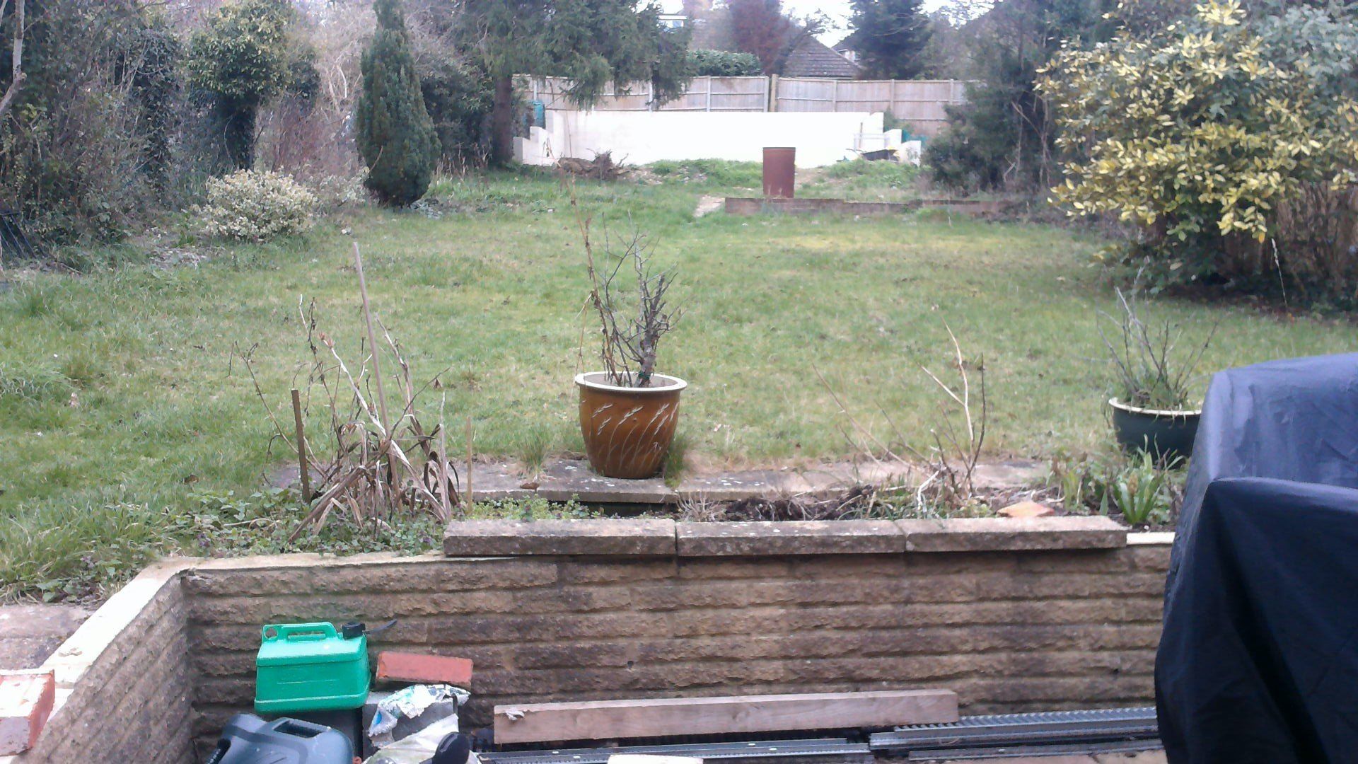 A green container sits in the middle of a garden