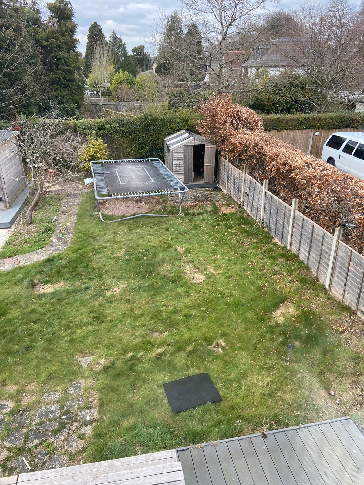 An aerial view of a backyard with a trampoline and a shed.