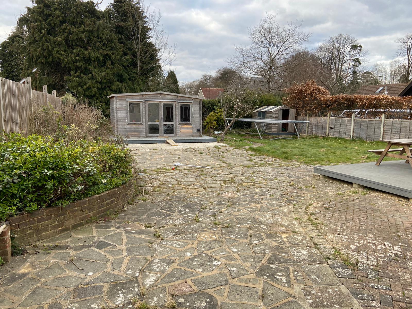 There is a stone path leading to a shed in the backyard.