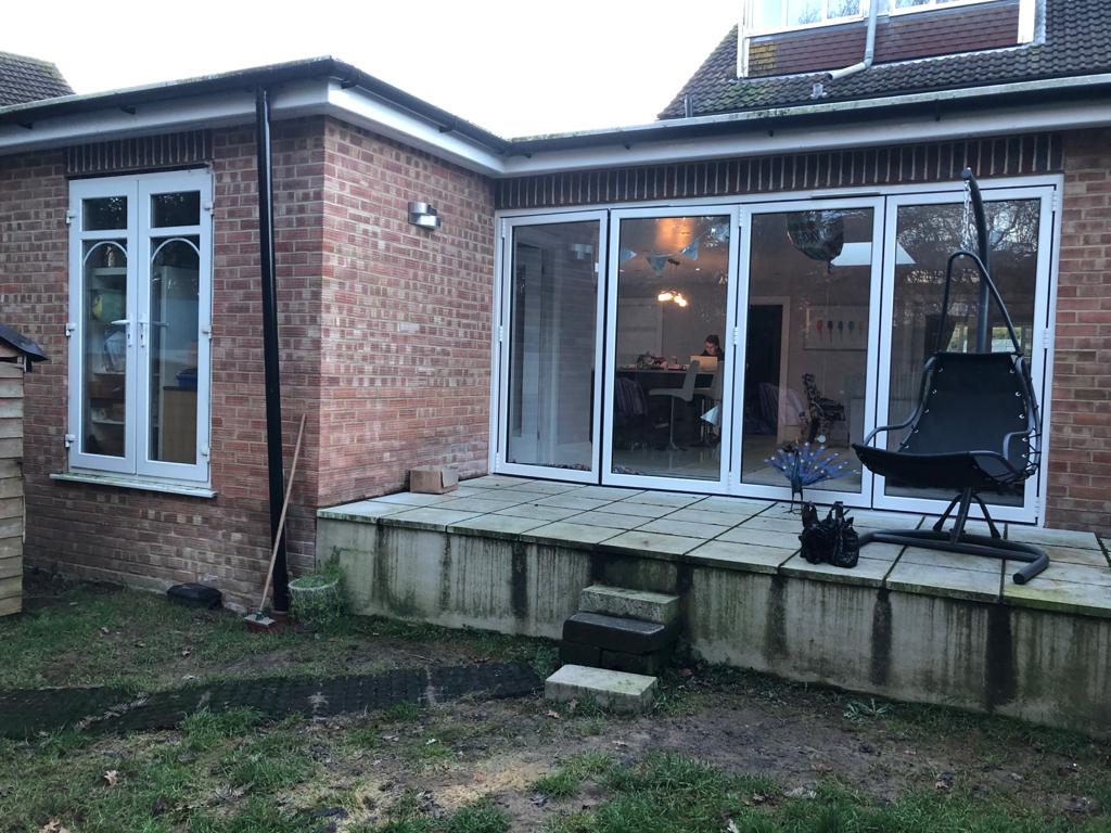 A brick house with a patio and sliding glass doors.