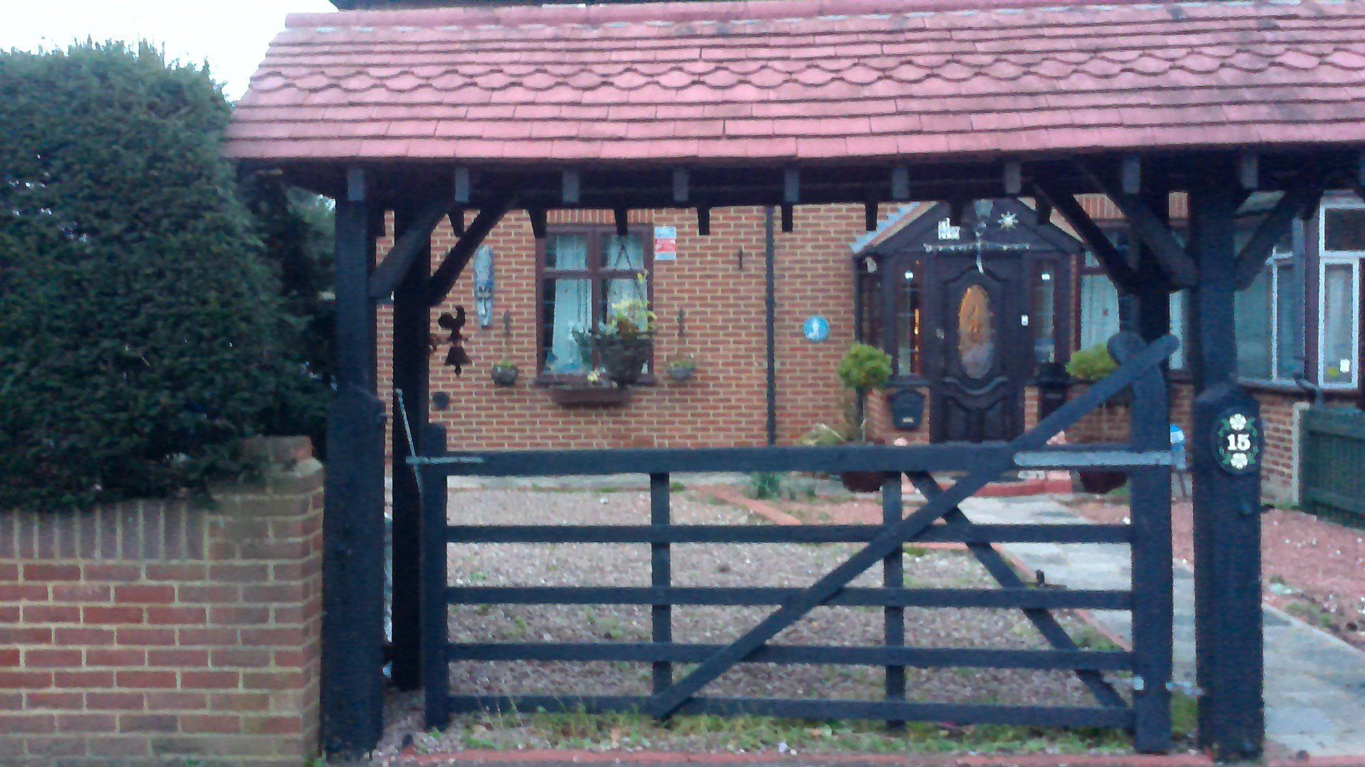 A black gate is in front of a brick house.