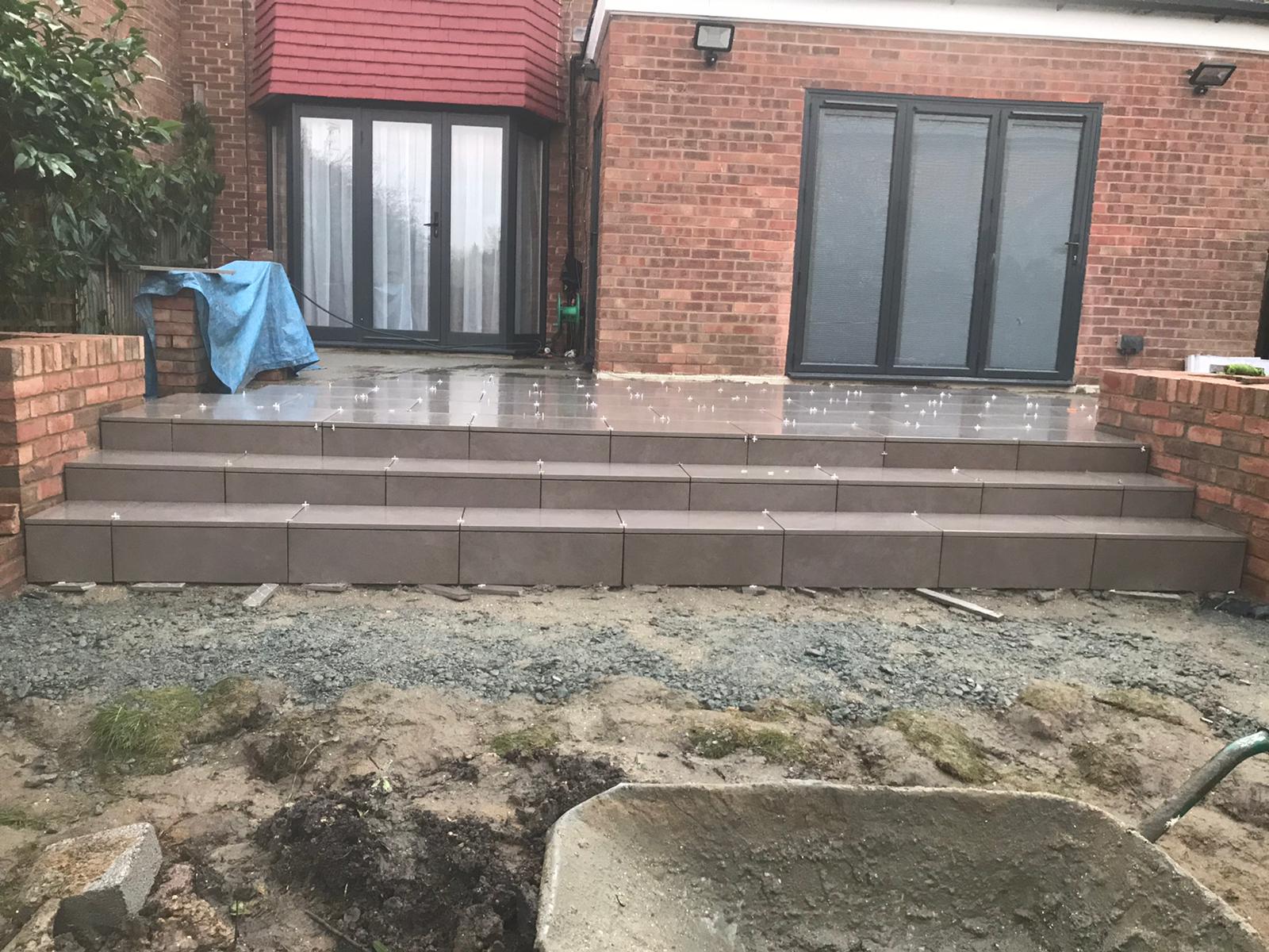 There is a wheelbarrow in the dirt in front of a brick building.