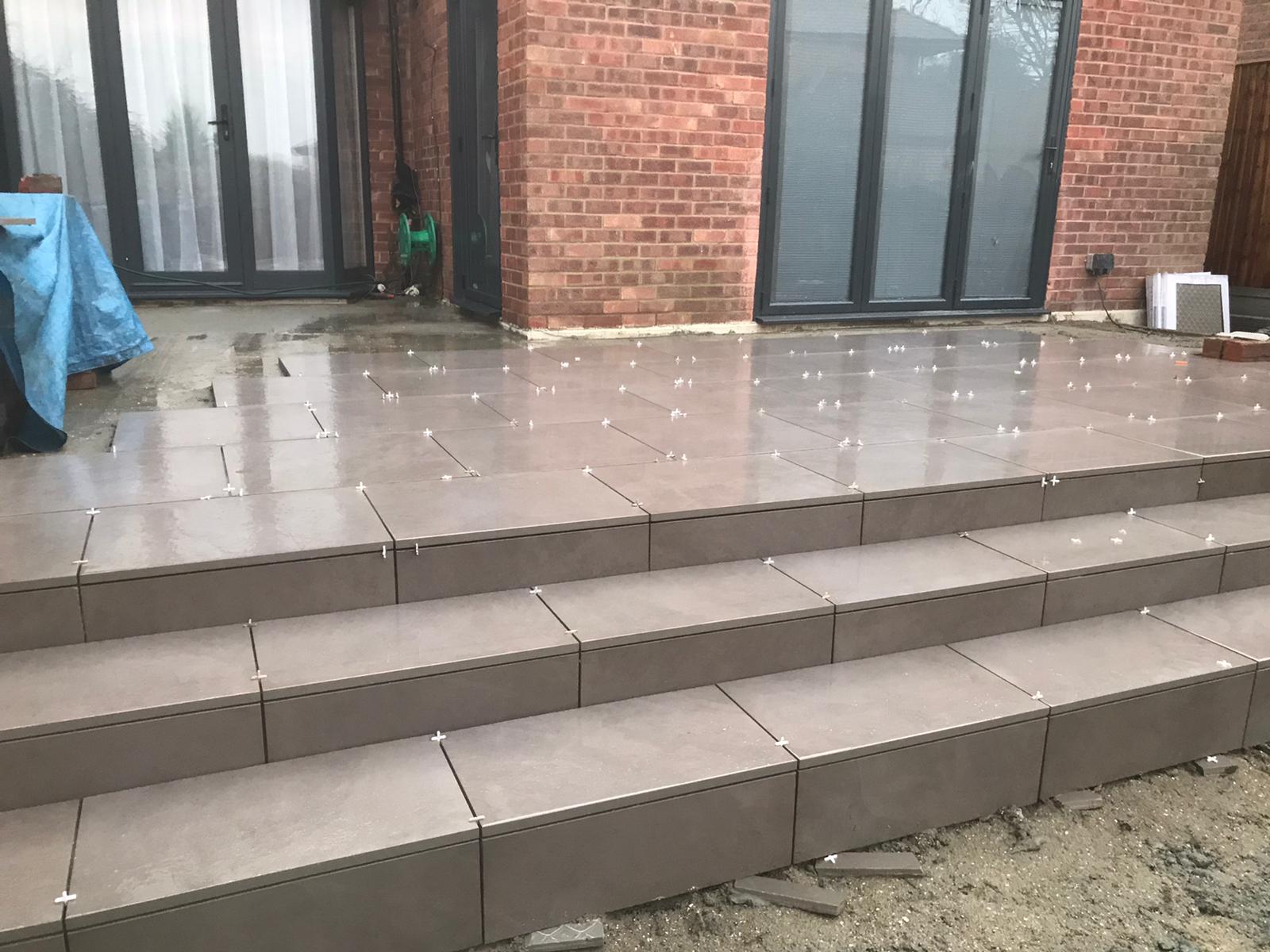 A brick building with a patio and stairs in front of it.