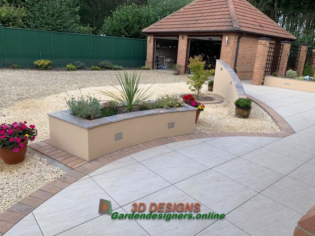 A garden with a brick building in the background and a sign that says 3d designs