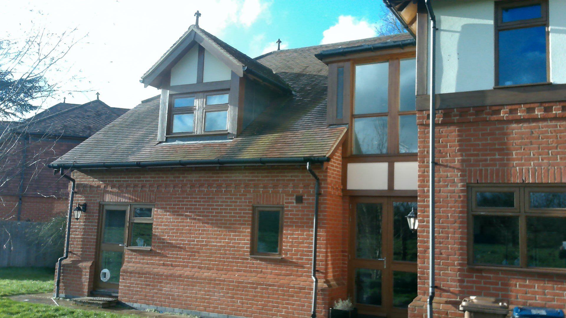 A large brick house with a lot of windows and a roof.