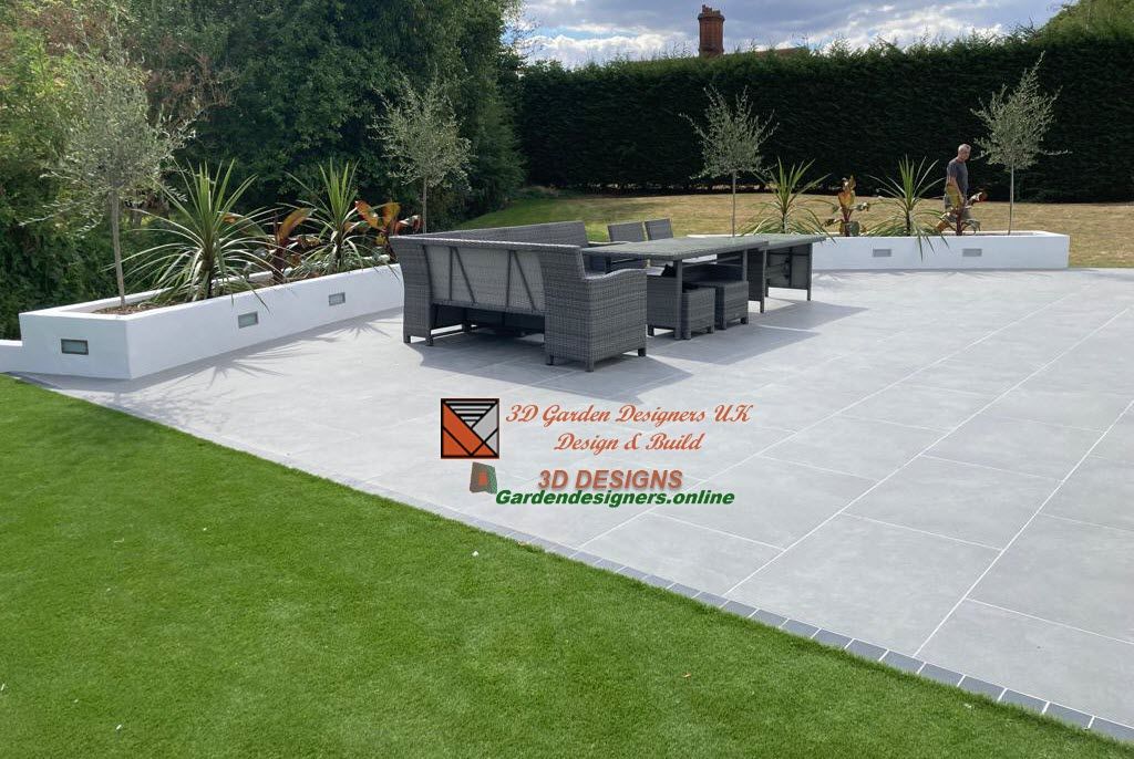 paving design and build A patio with a table and chairs in a garden