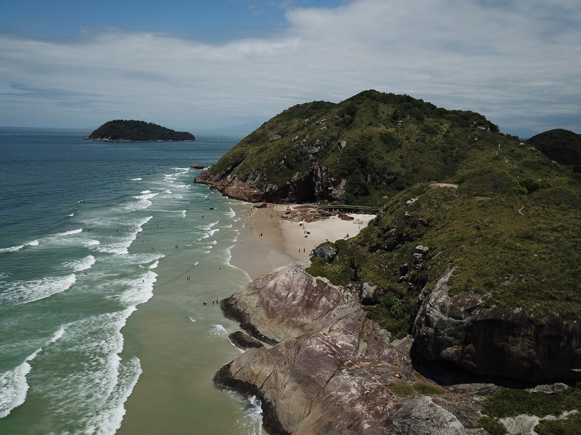 Uma vista aérea de uma praia com uma pequena ilha ao longe
