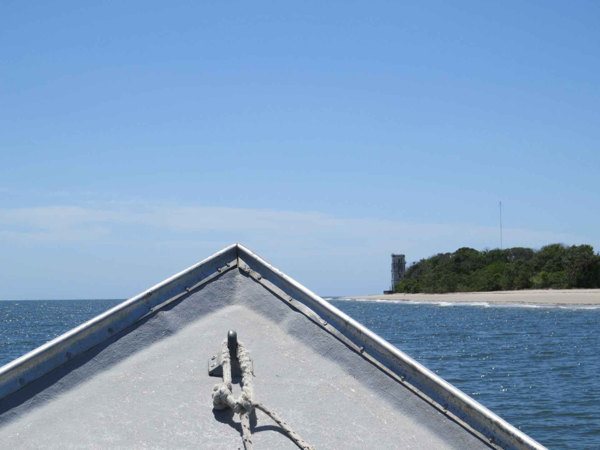 A frente de um barco com um farol ao fundo