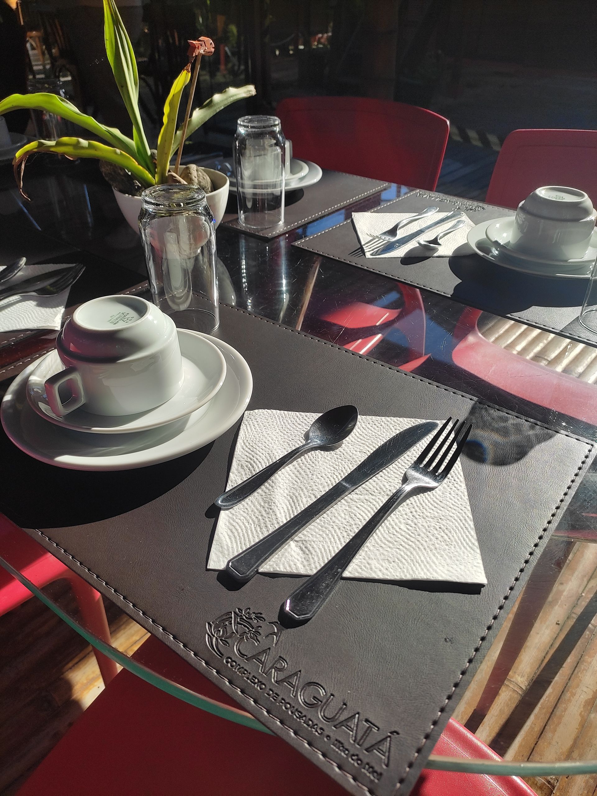 Uma mesa com pratos, utensílios e uma planta sobre ela