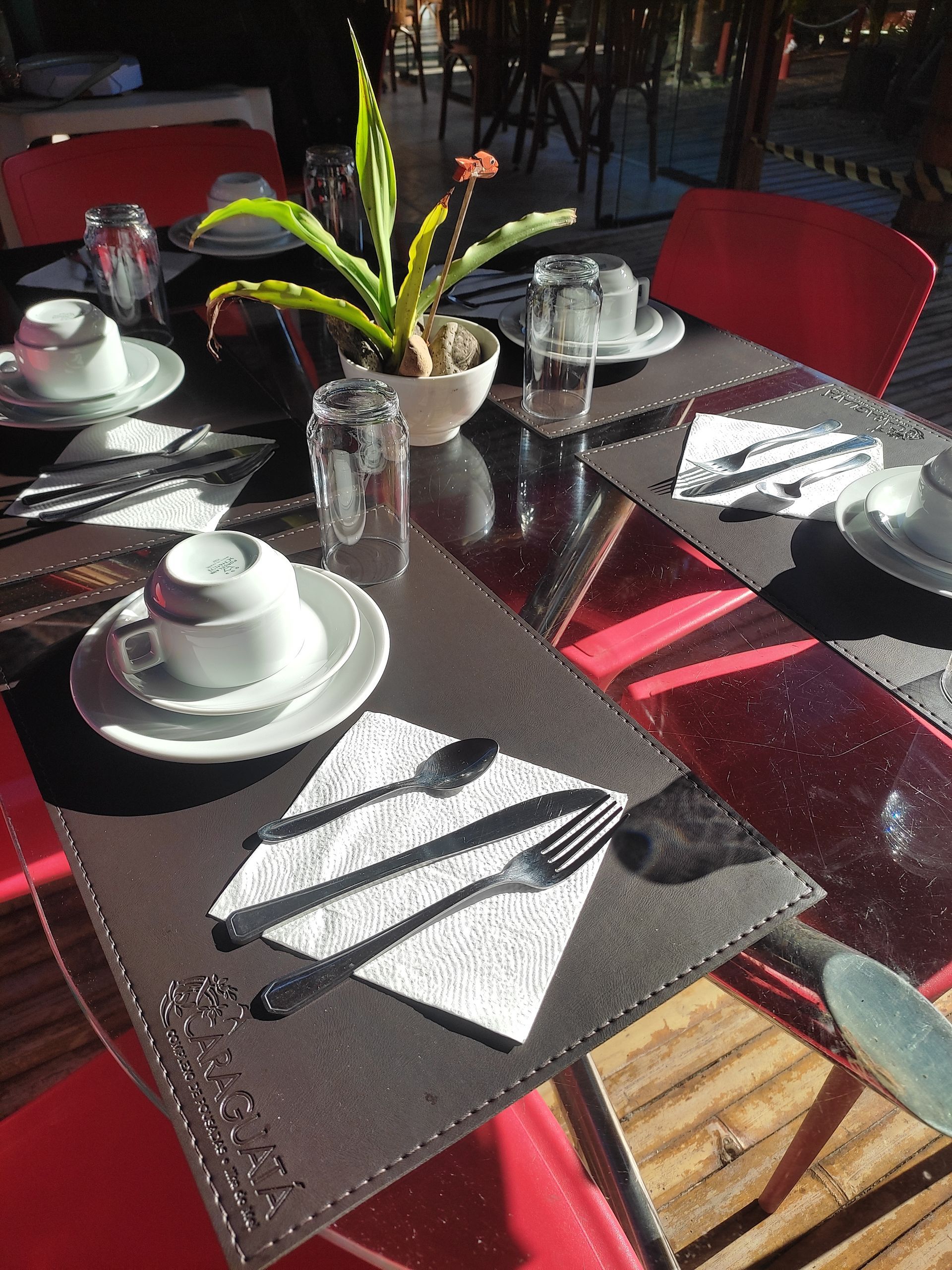 Uma mesa com pratos, xícaras, copos e utensílios sobre ela