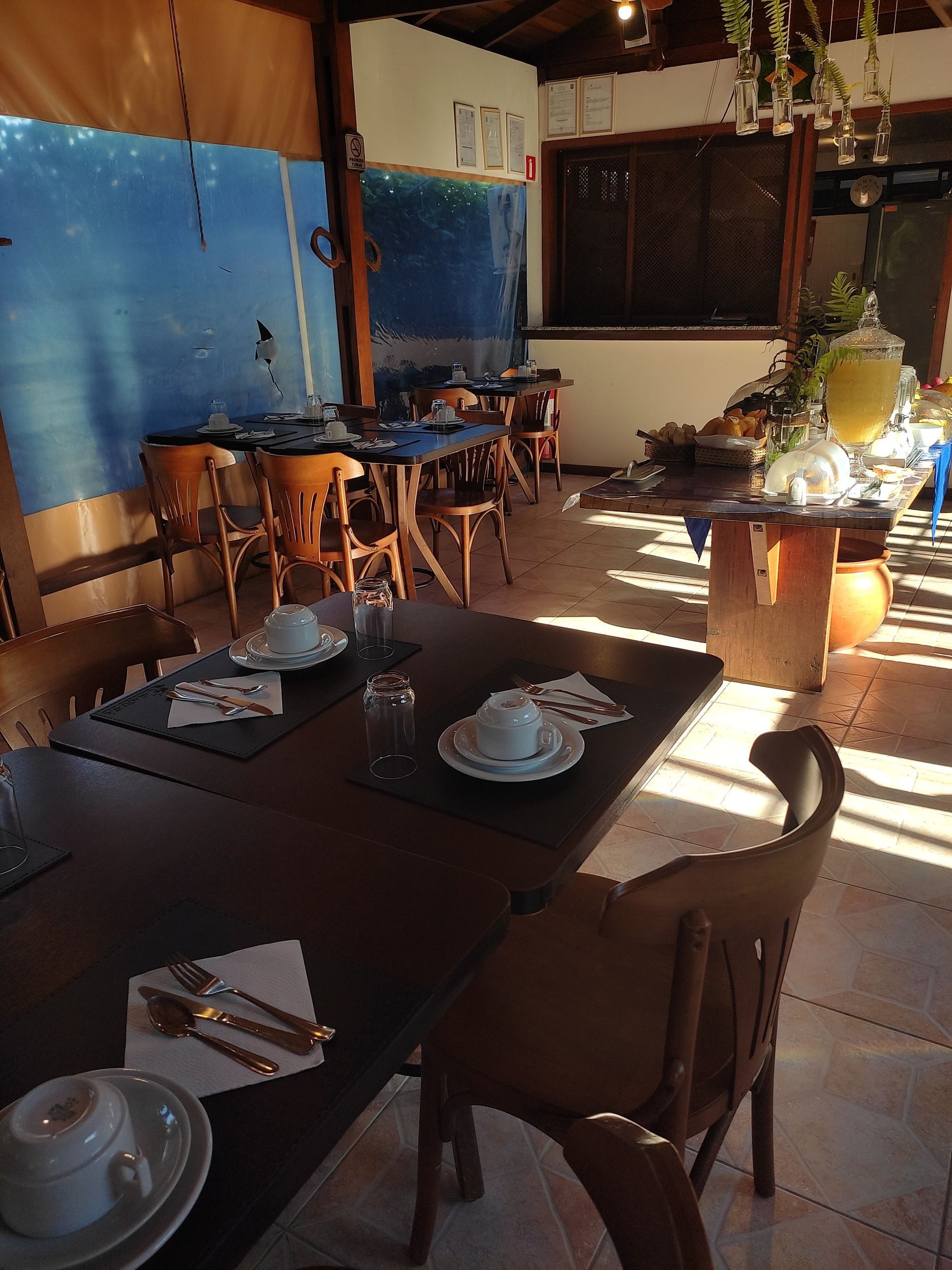 Uma sala de jantar com mesas, cadeiras e pratos sobre elas