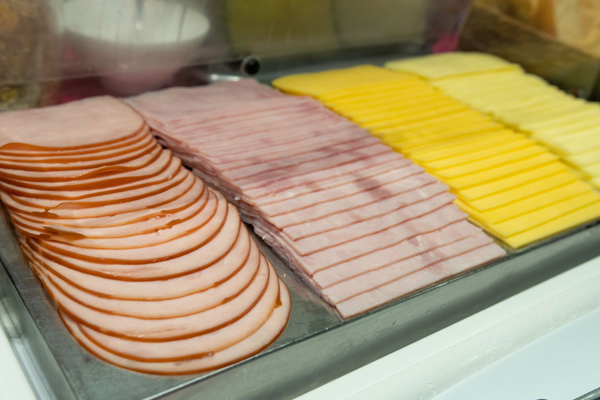Uma variedade de carnes fatiadas e queijos estão em uma bandeja.