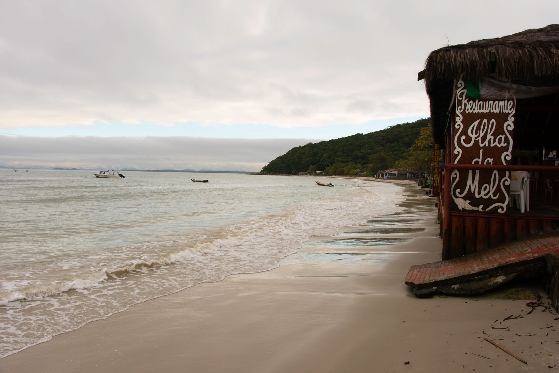 Uma praia com uma cabana de palha que diz 
