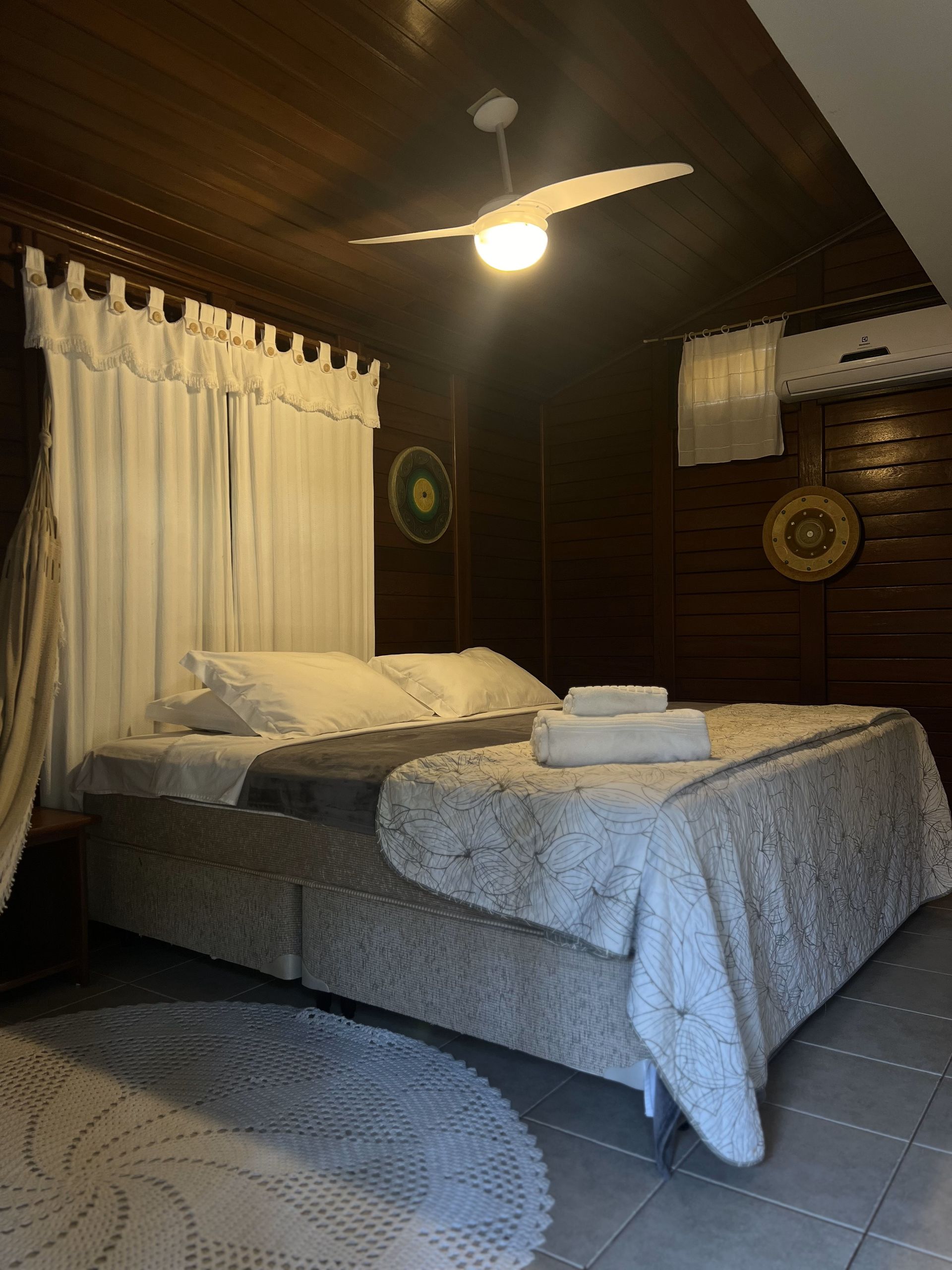 Um quarto com uma cama e um ventilador de teto.