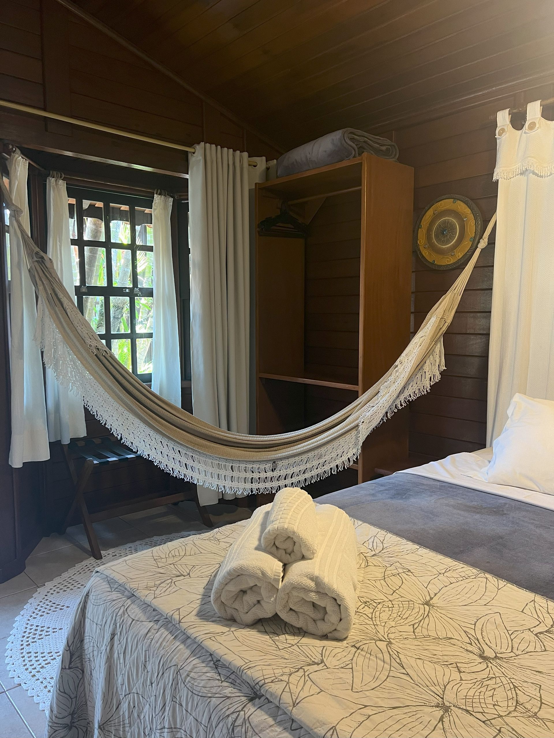 Um quarto com rede e toalhas na cama.