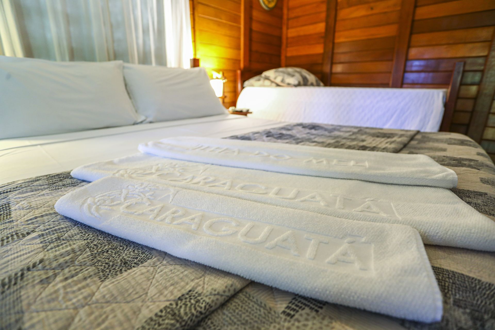Um quarto de hotel com uma cama e duas toalhas que dizem paraguaya