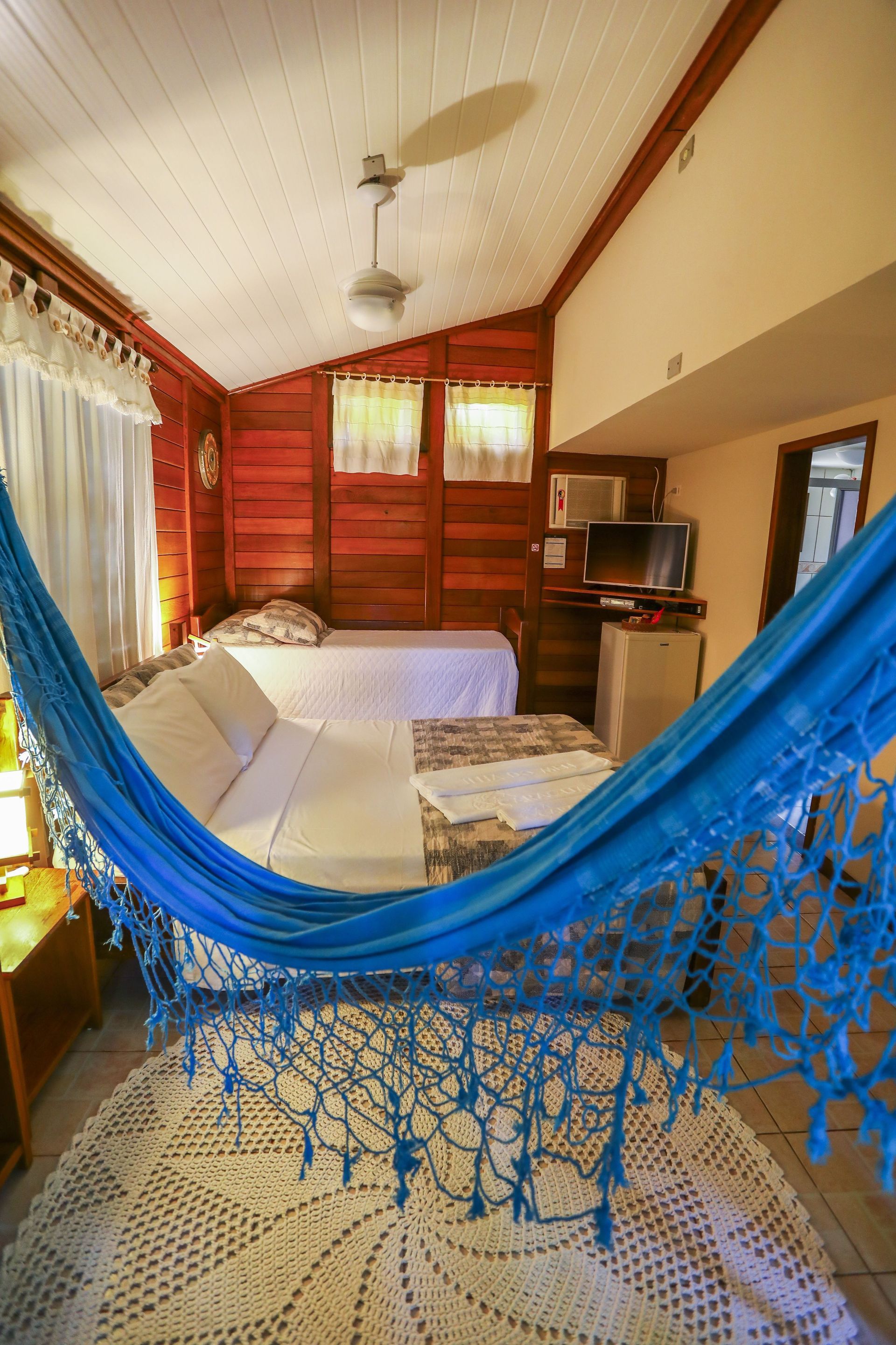 Há uma rede azul no meio da sala.