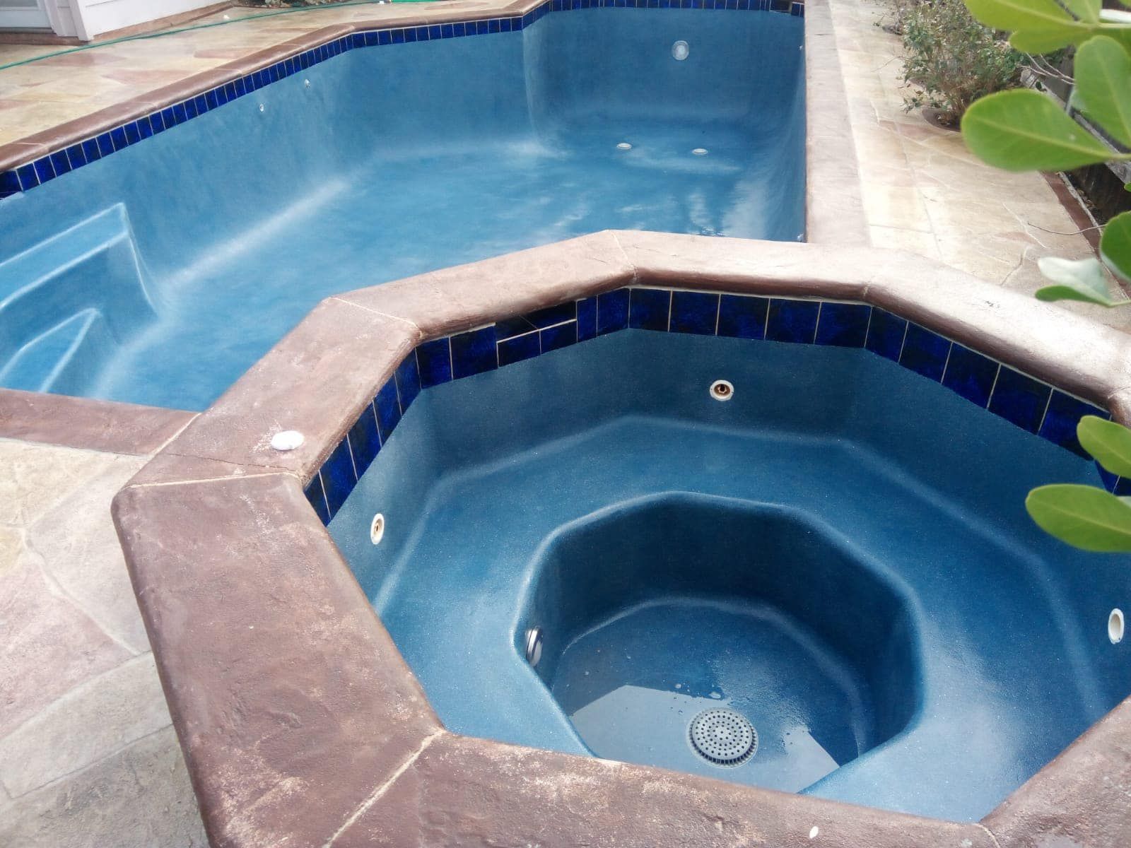 Blue pool with an octagonal hot tub and attached swimming pool, viewed from above