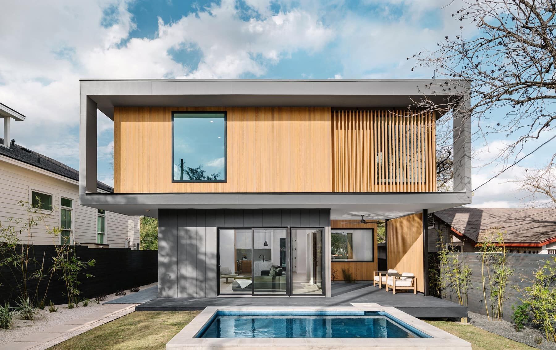 Modern two-story house with wood siding and a small backyard pool