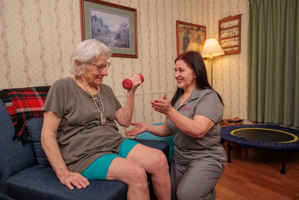 An elderly man is sitting in a chair with a puppy on his lap.