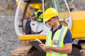 construction worker writing on clipboard