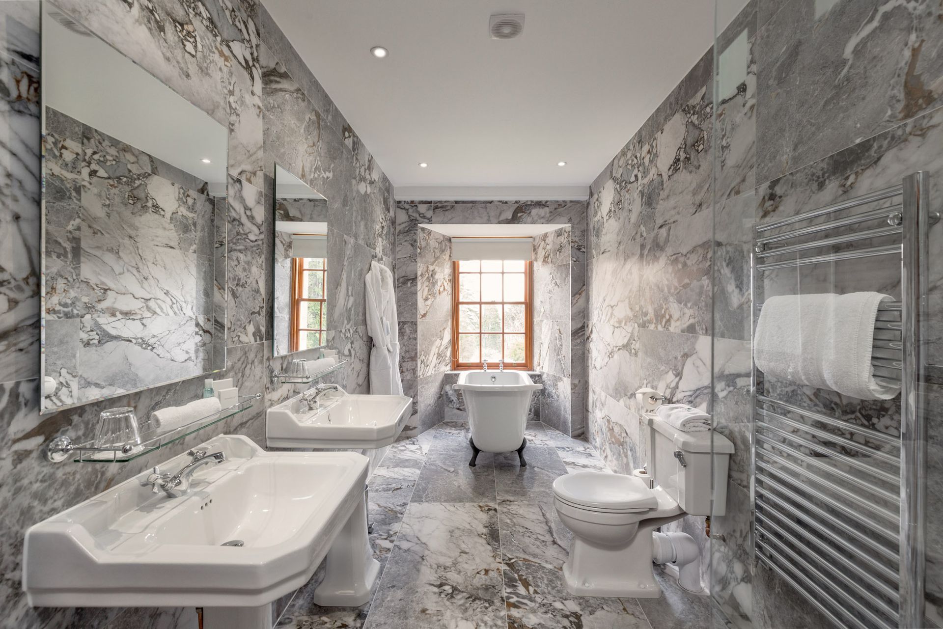 A bathroom with two sinks, a toilet and a bathtub.