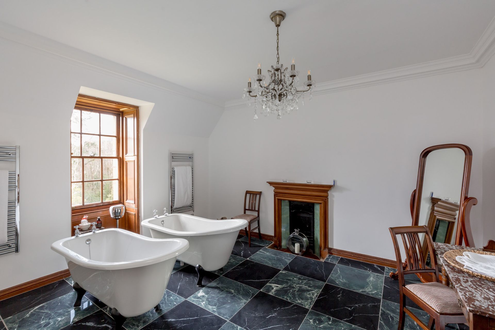 A bathroom with two bathtubs and a fireplace.
