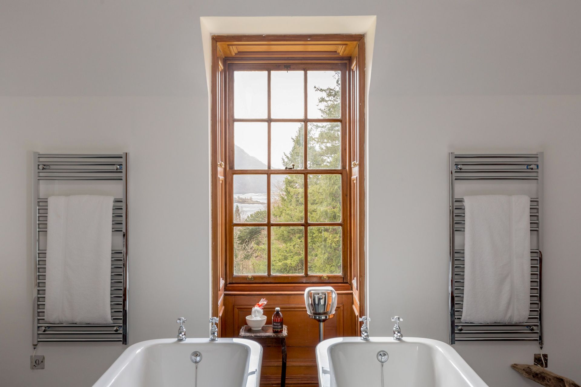 A bathroom with two bathtubs and a window.