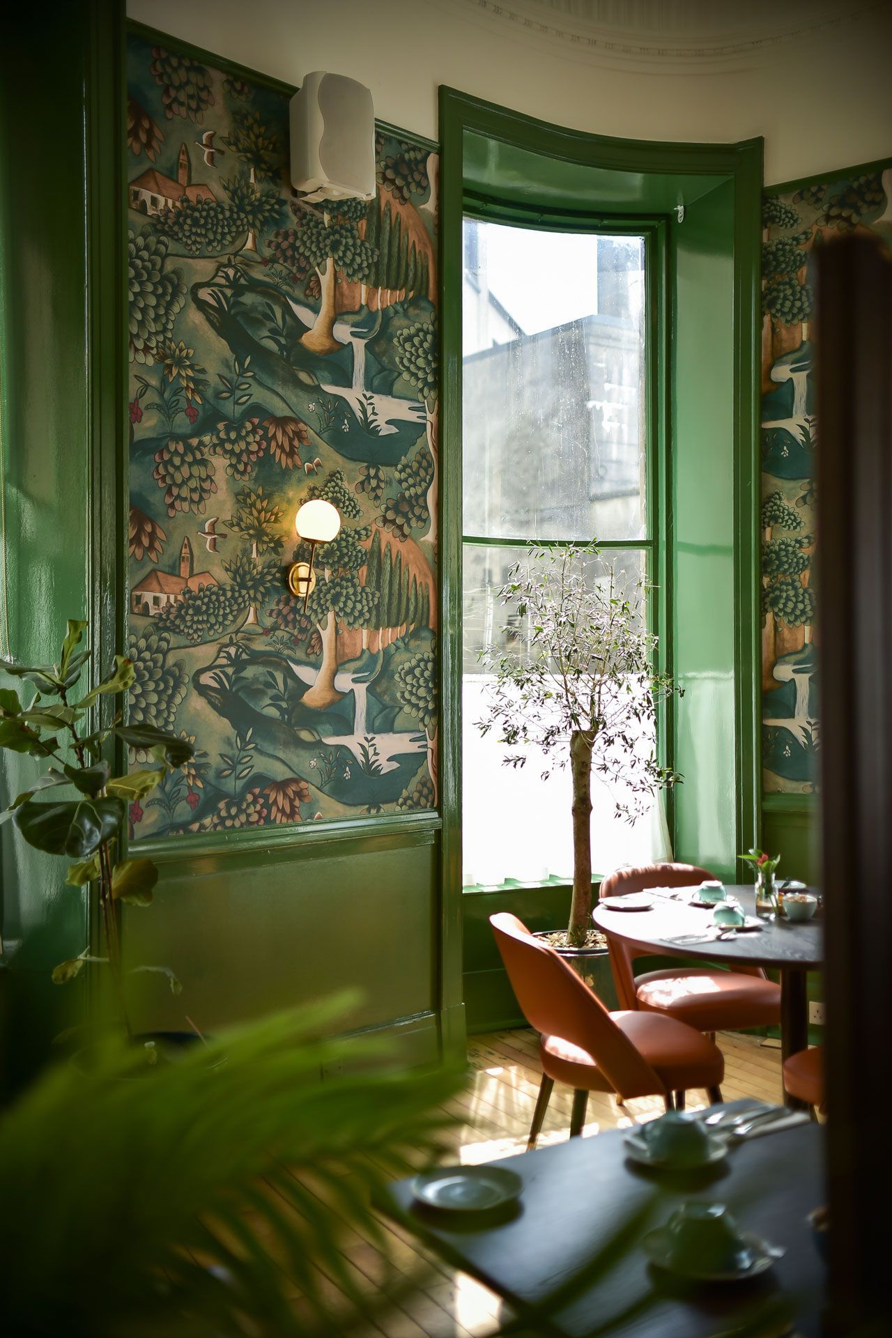 A room with tables and chairs and a large window.