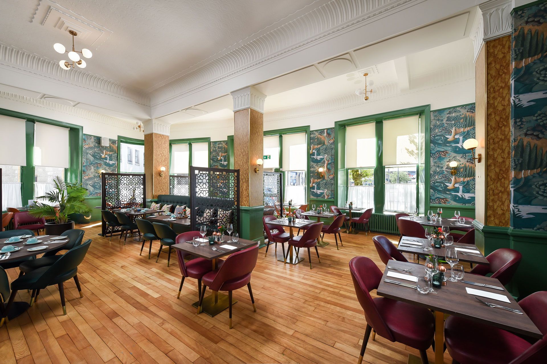 A large dining room with wooden floors and tables and chairs.