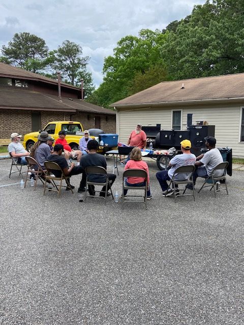 A group of people are sitting in a circle in a parking lot