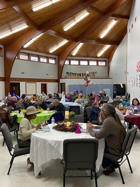 A group of people are sitting at tables in a large room.