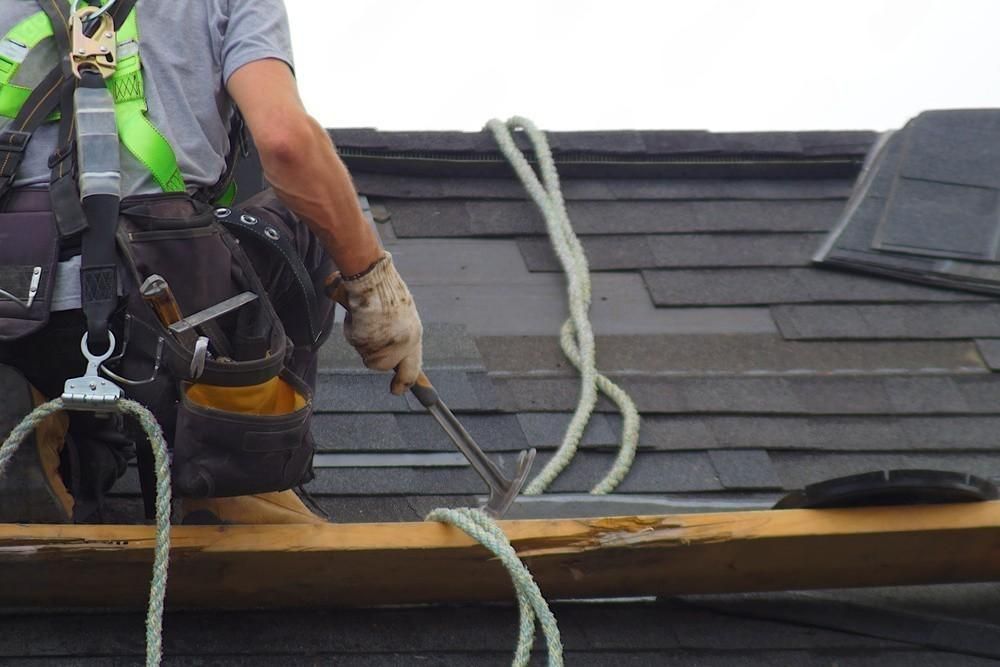 a man is working on a roof with a hammer .